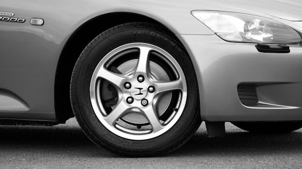 Detailed view of alloy wheel on a sleek gray sports car, showcasing automotive design.